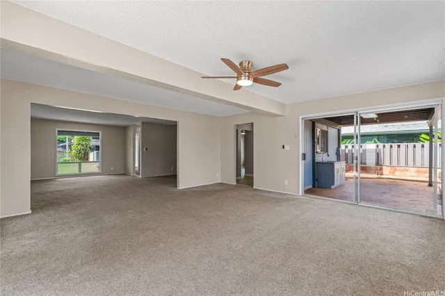 a view of a livingroom with a ceiling fan and window