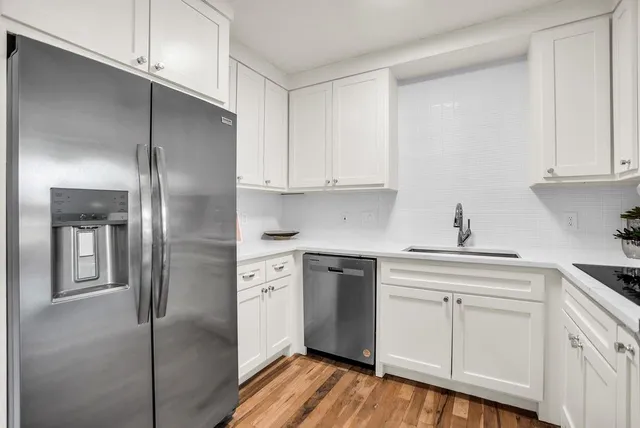 a kitchen with cabinets stainless steel appliances and a refrigerator