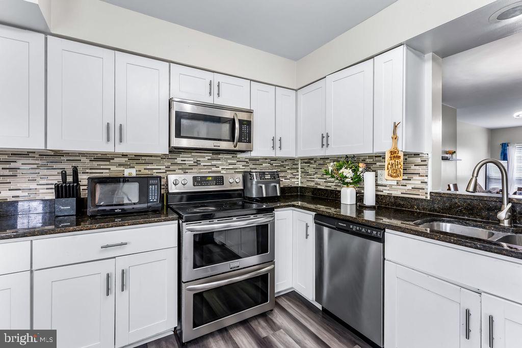 11409 Hermosa Drive Laurel, MD 20708 - Photo 11 of 28 a kitchen with granite countertop white cabinets and stainless steel appliances