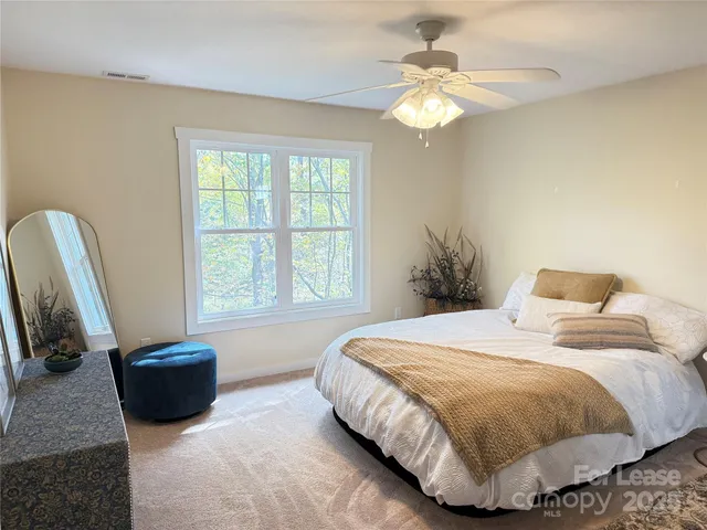 a bedroom with a bed and a large window
