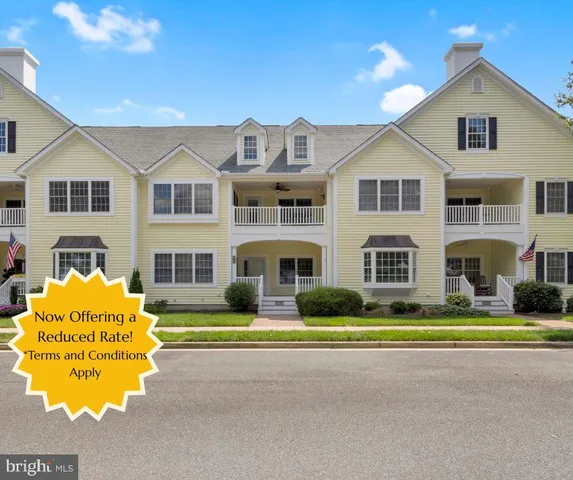 a front view of residential houses with yard and road
