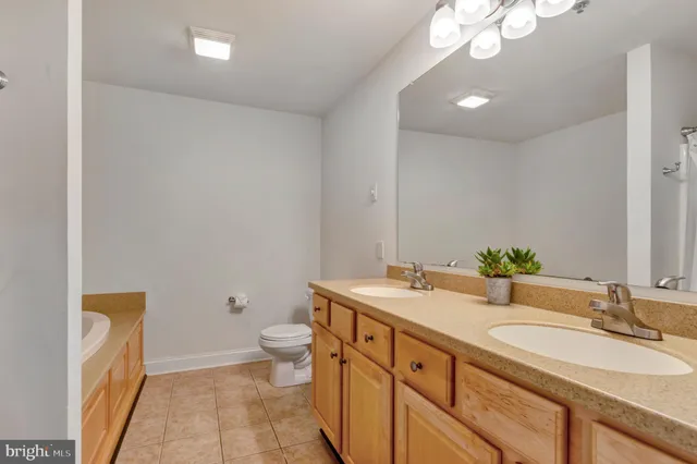 a bathroom with a granite countertop sink a toilet and a mirror