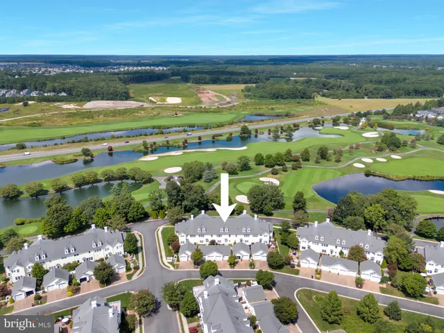 an aerial view of ocean and residential houses with outdoor space
