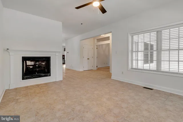 an empty room with windows fireplace and sink