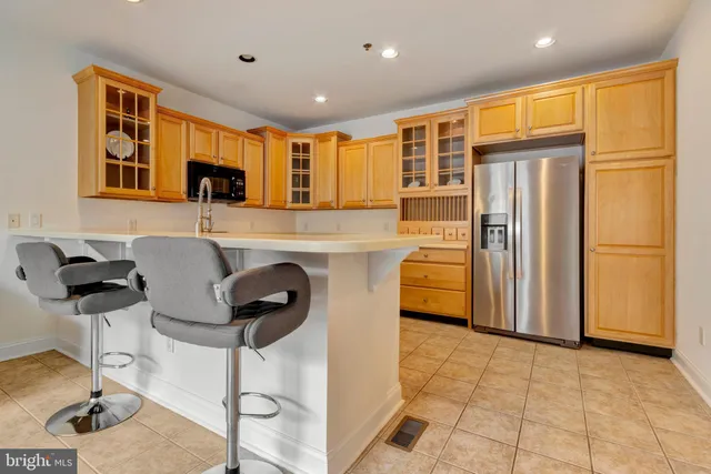 a kitchen with stainless steel appliances granite countertop a refrigerator and a stove top oven