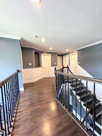 a view of a hallway with wooden floor and windows
