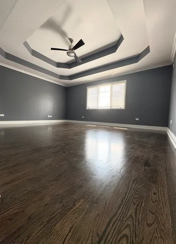 an empty room with wooden floor and windows in it
