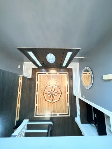 a view of an entryway with sitting space and a wooden floor