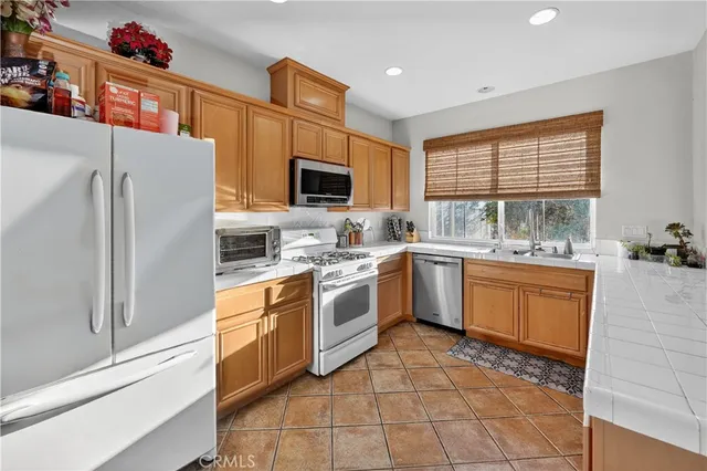a kitchen with stainless steel appliances sink cabinets and window