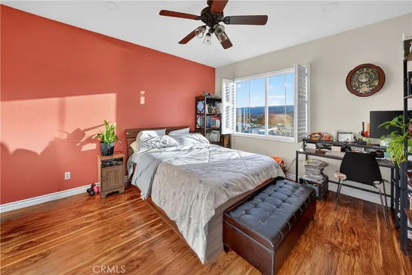 a bedroom with a bed a large window and a chandelier
