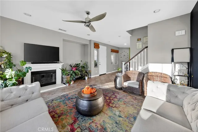 a living room with furniture a fireplace and a flat screen tv