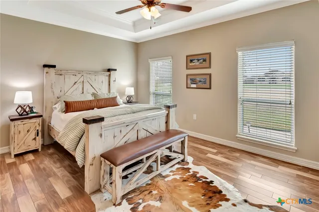a view of a workspace with wooden floor and a window