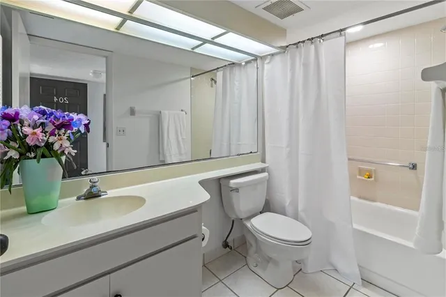a bathroom with a sink a toilet a mirror and shower curtain
