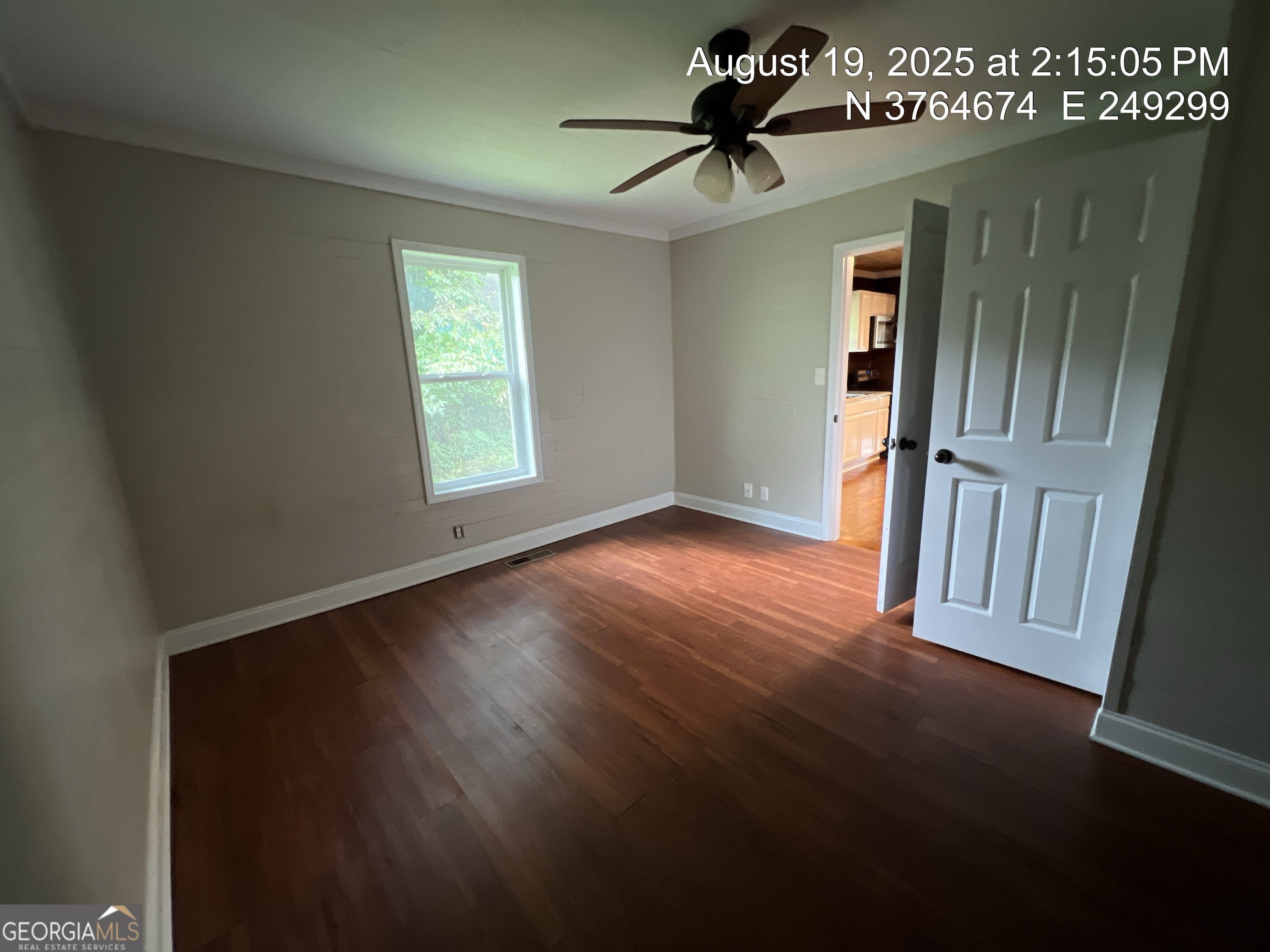 186 Georgia Avenue, Unit B Winder, GA 30680 - Photo 13 of 24 an empty room with wooden floor fan and windows