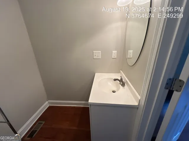 a white toilet sitting next to a bathroom sink and a mirror