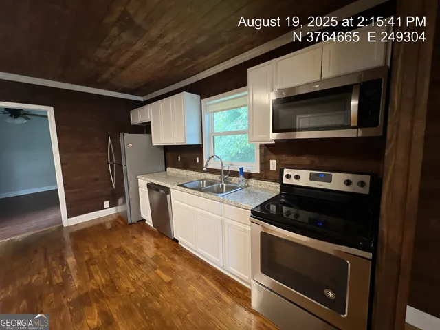 a kitchen with stainless steel appliances a stove a microwave and a sink
