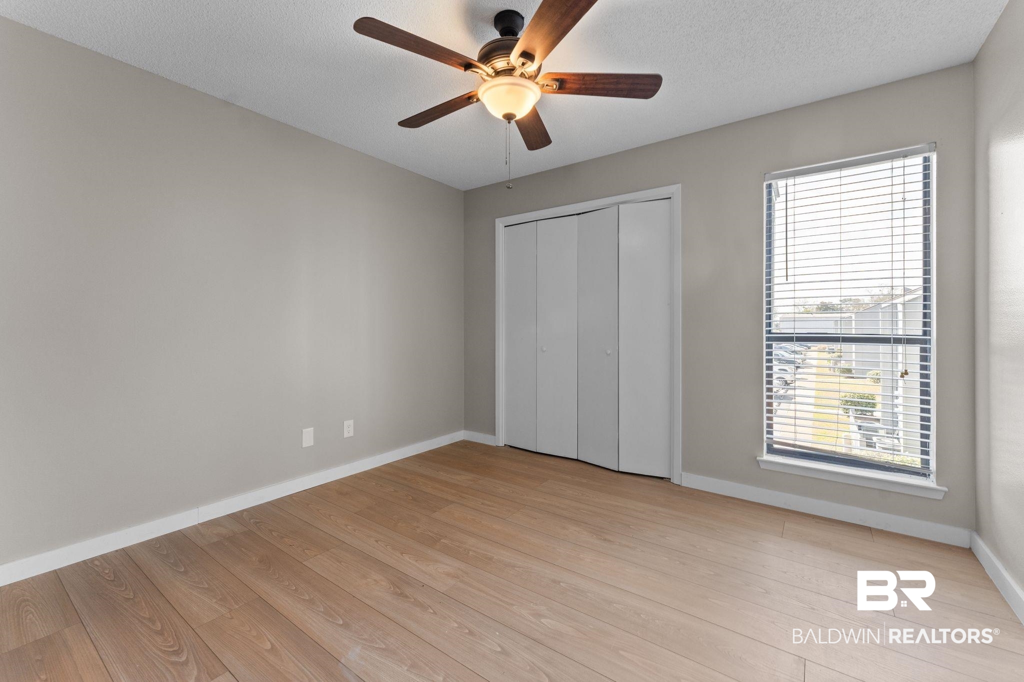 128 West Satsuma Avenue, Unit 128 Foley, AL 36535 - Photo 14 of 41 Unfurnished bedroom with ceiling fan, light wood finished floors, a textured ceiling, and a closet
