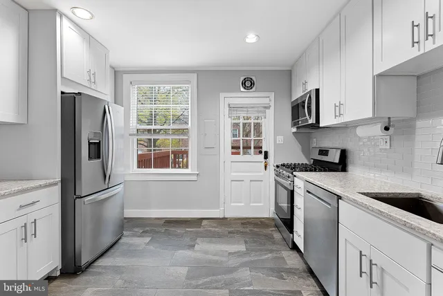 a kitchen with stainless steel appliances granite countertop a refrigerator sink and stove
