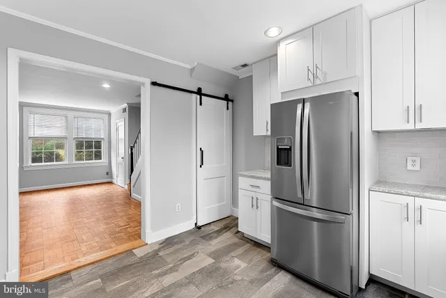 a metallic refrigerator freezer sitting in a kitchen