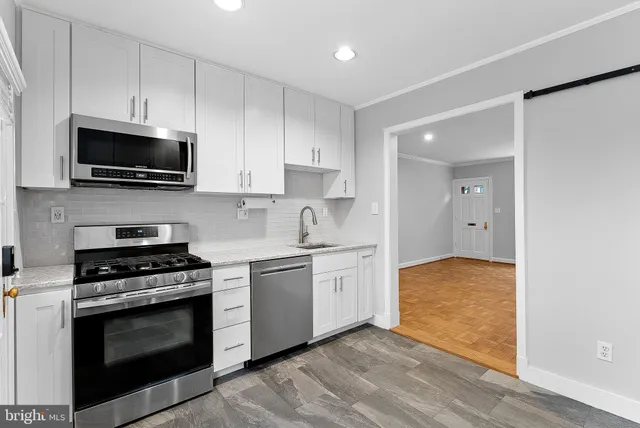 a kitchen with cabinets stainless steel appliances and wooden floor