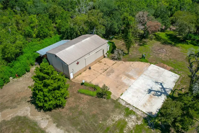 a view of a house with a yard and large trees