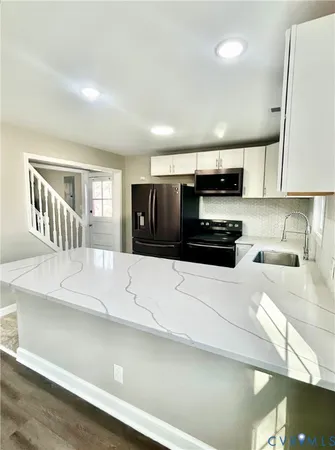 a kitchen with kitchen island a counter top space a stove and cabinets