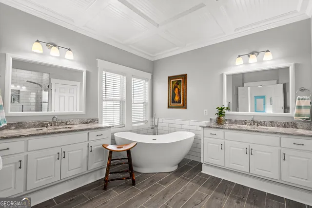 a spacious bathroom with a double vanity sink bathtub and next to a window