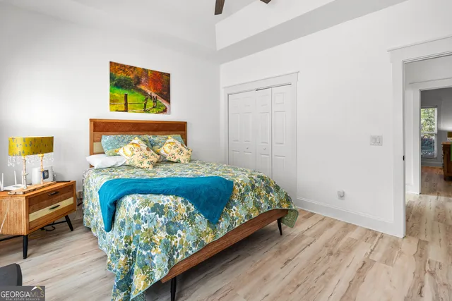 a bedroom with a bed and painting on the wall