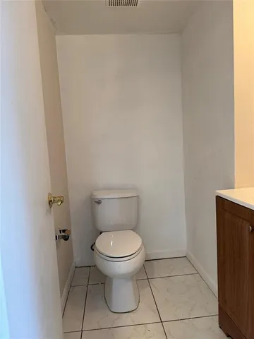 a white toilet sitting next to a white wall