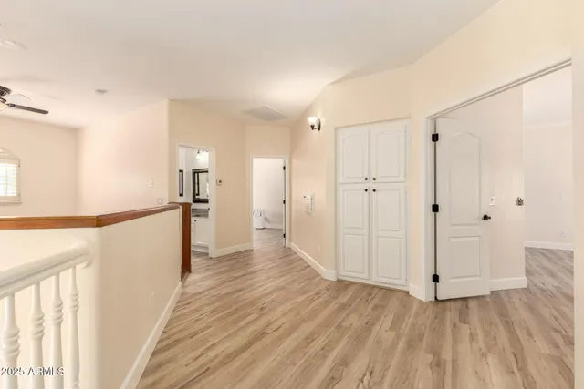 a view of a hallway with wooden floor and staircase