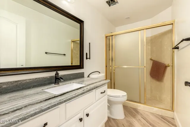 a bathroom with a granite countertop sink toilet and shower