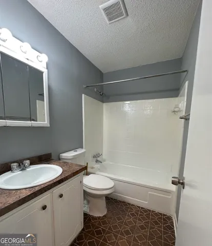 a bathroom with a granite countertop sink toilet a mirror and shower