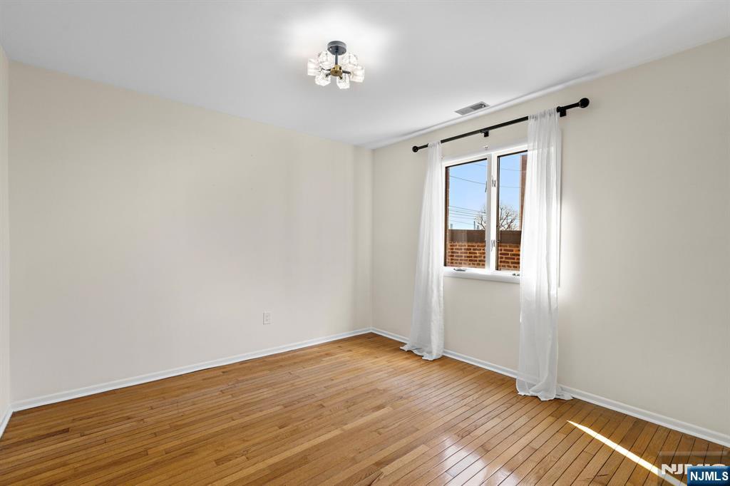 319 Gorge Road, Unit 6 Cliffside Park, NJ 07010 - Photo 7 of 24 a view of empty room with wooden floor and fan