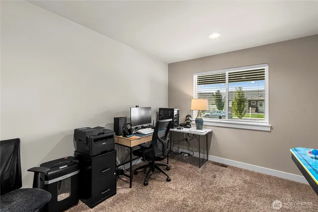 a view of a workspace with furniture and a window