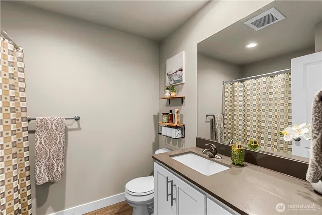 a bathroom with a sink toilet vanity and shower