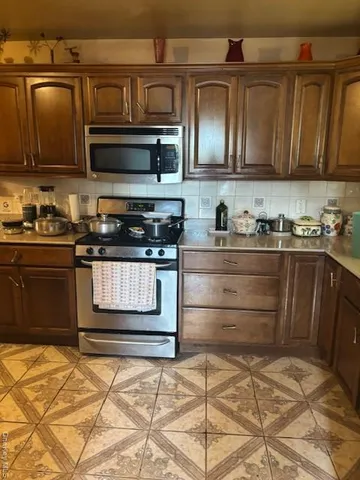 a kitchen with stainless steel appliances granite countertop a stove and a microwave oven