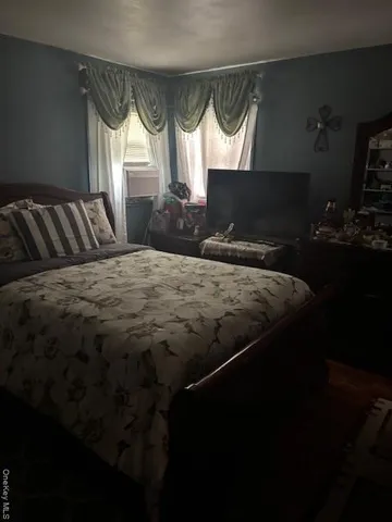 a bed sitting in a bedroom next to a window