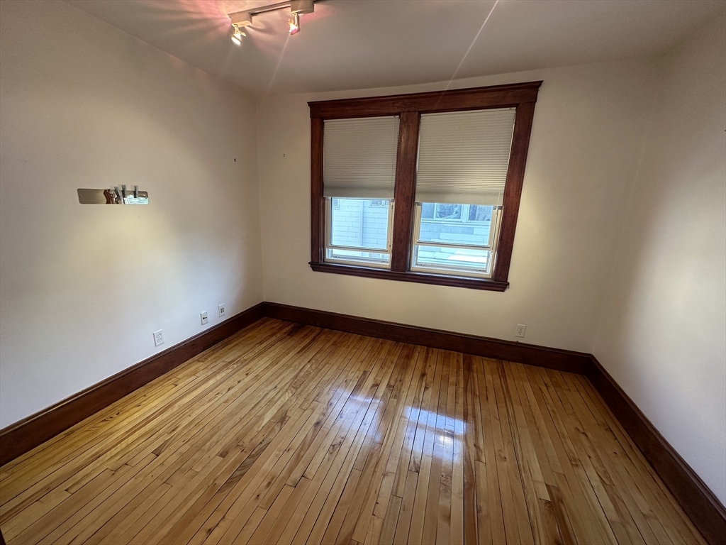17 Herbert Road, Unit 1 Arlington, MA 02474 - Photo 8 of 26 a view of an empty room with wooden floor and a window