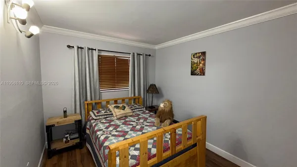 a bedroom with bed and wooden floor