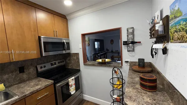 a kitchen with stainless steel appliances granite countertop a stove and a wooden cabinets