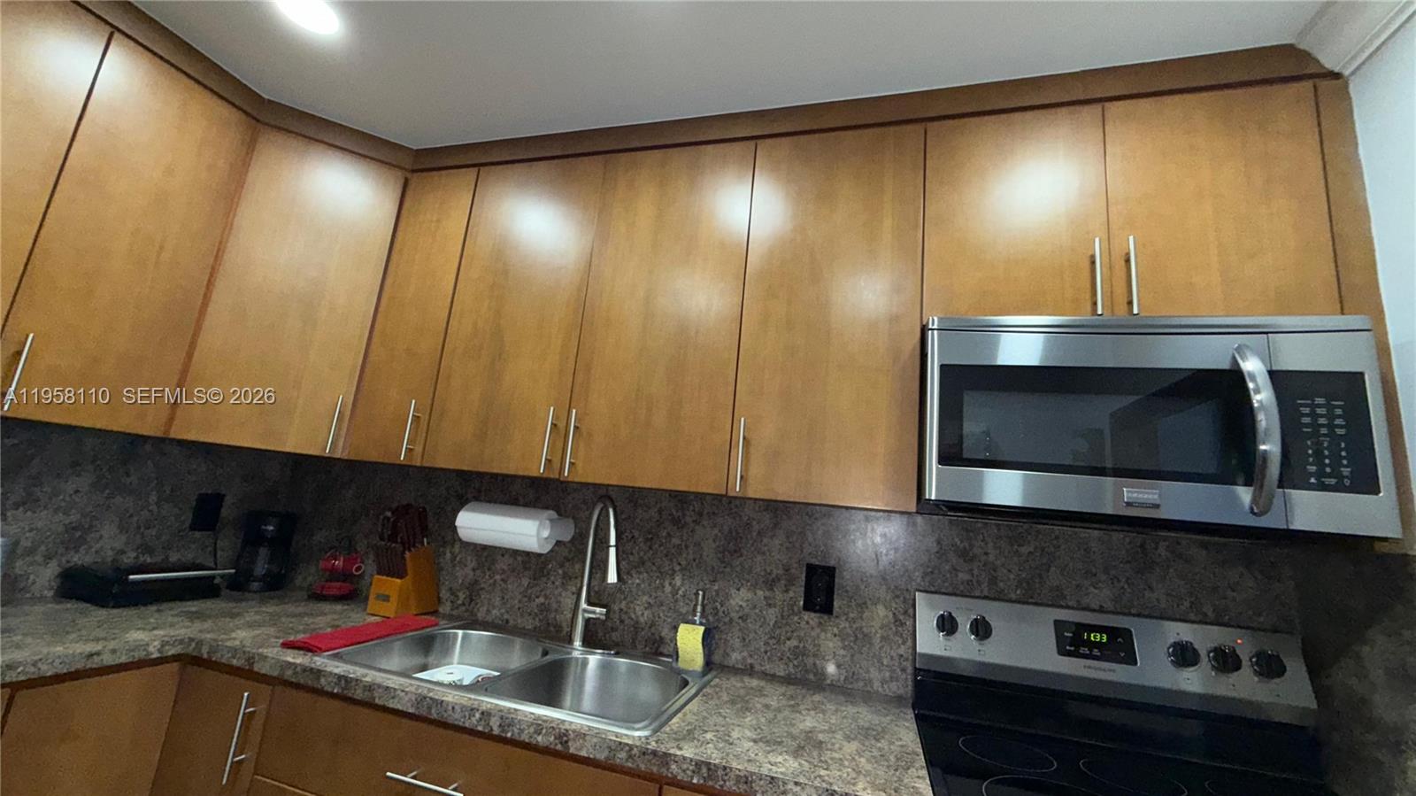 1075 West 68th Street, Unit 403 Hialeah, FL 33014 - Photo 7 of 25 a kitchen with a sink and cabinets