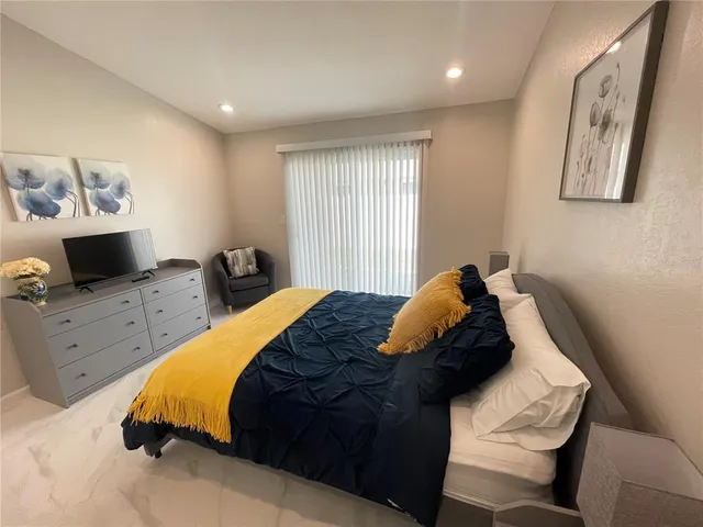 a bedroom with a bed and flat screen tv