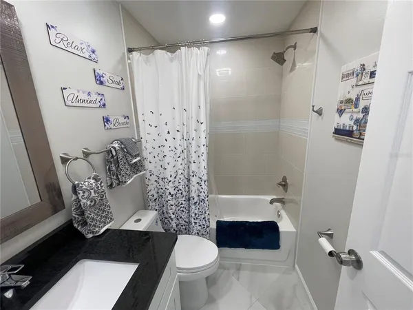 a bathroom with a sink a toilet and a shower