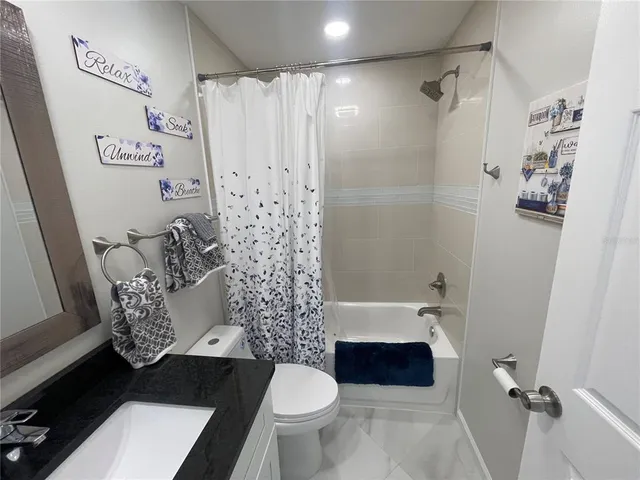 a bathroom with a sink a toilet and a shower