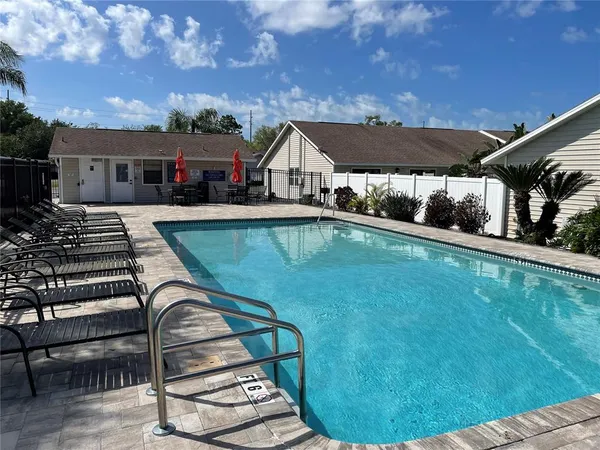 a view of a house with pool and sitting area