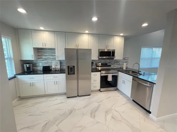 a kitchen with stainless steel appliances a refrigerator and a stove top oven