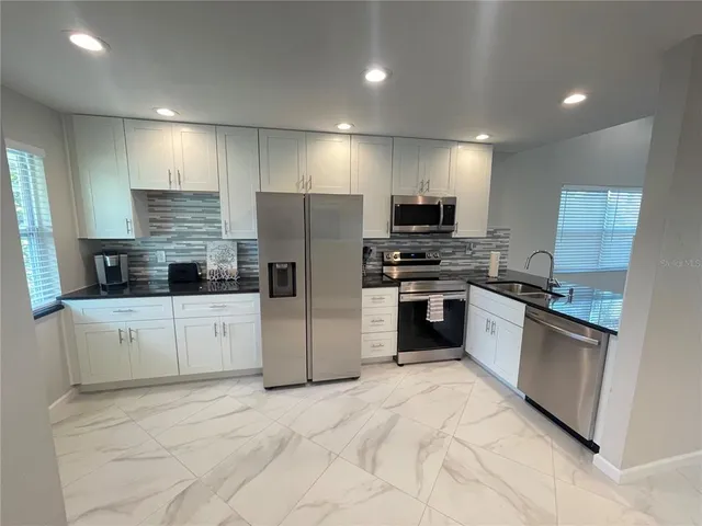 a kitchen with stainless steel appliances a refrigerator and a stove top oven