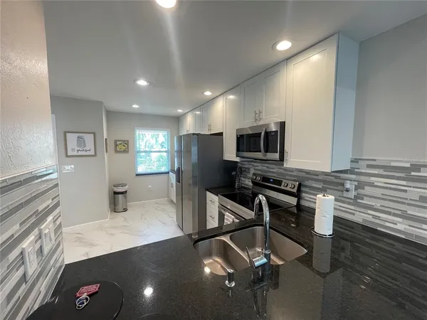 a kitchen with a sink appliances and cabinets