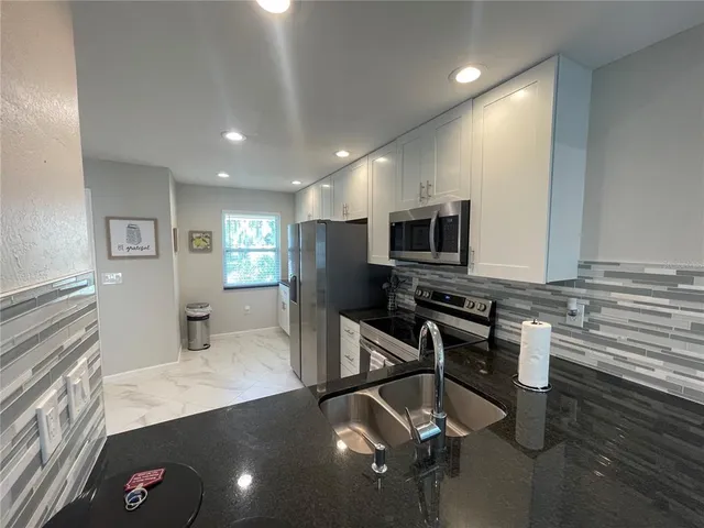 a kitchen with a sink appliances and cabinets