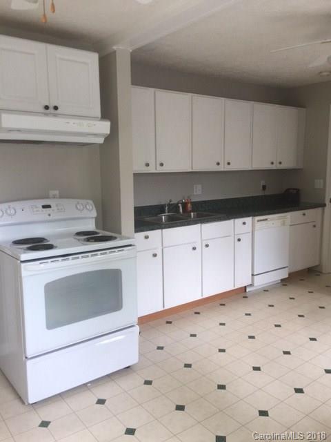 977 Soco Road Maggie Valley, NC 28751 - Photo 6 of 12 a kitchen with granite countertop white cabinets and white appliances
